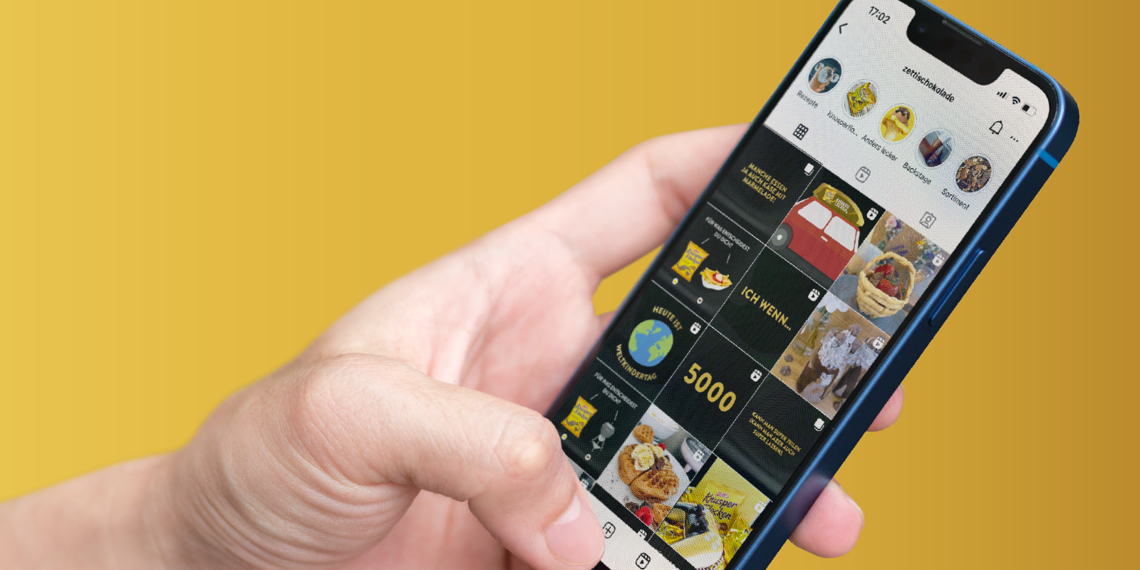 Hand hält ein Handy. Auf dem Bildschirm ist ein Instagram Profil zu sehen