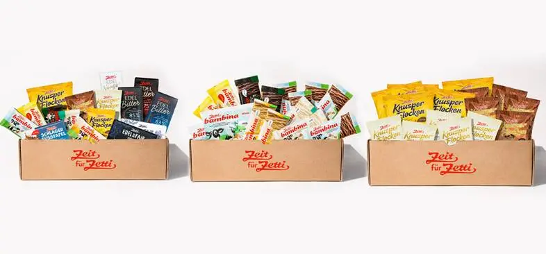 Drei Kartons gefüllt mit diversen Zetti Produkten. Darinter Knusperflocken, Schokotafeln und Riegel