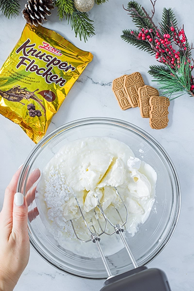 Eine Schüssel mit weißer Creme und Handrührgerät darin.