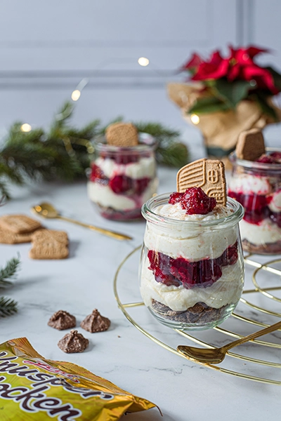 Schichtdessert mit Sahnecreme, weißen Kirschen und Knusperflocken